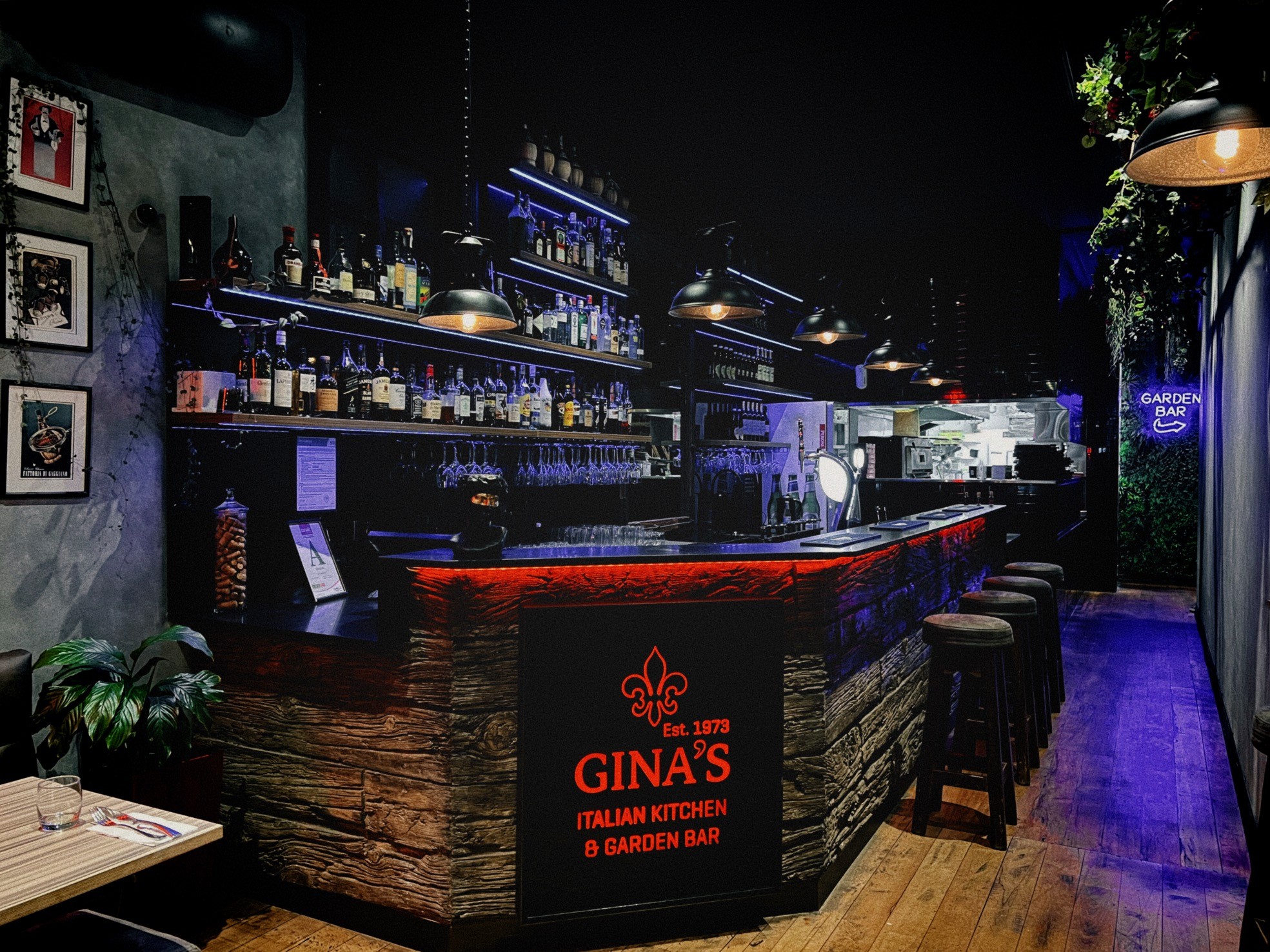 The bar and garden-bar room at Gina's, lit warm at night