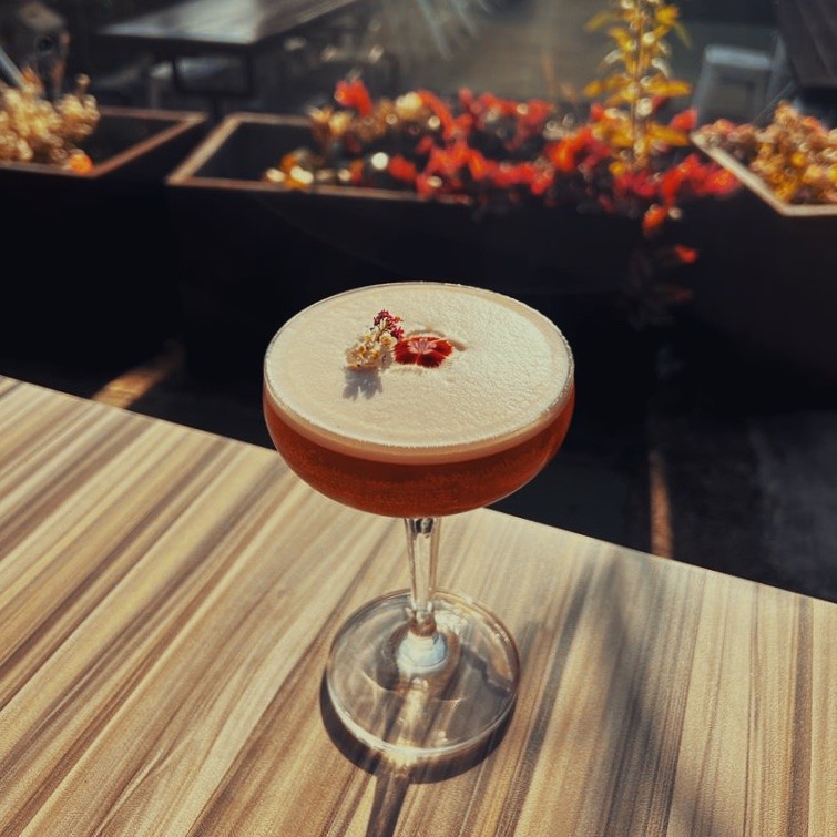 A cocktail on a sunny table in the courtyard at Gina's